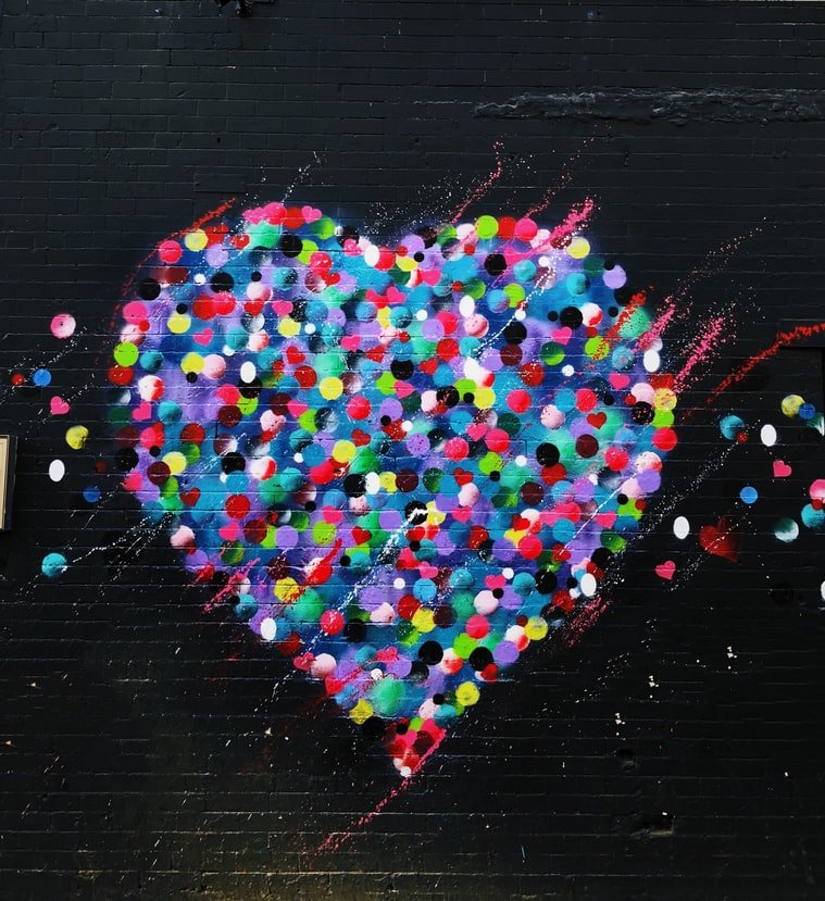 Coração colorido pintado em parede preta
