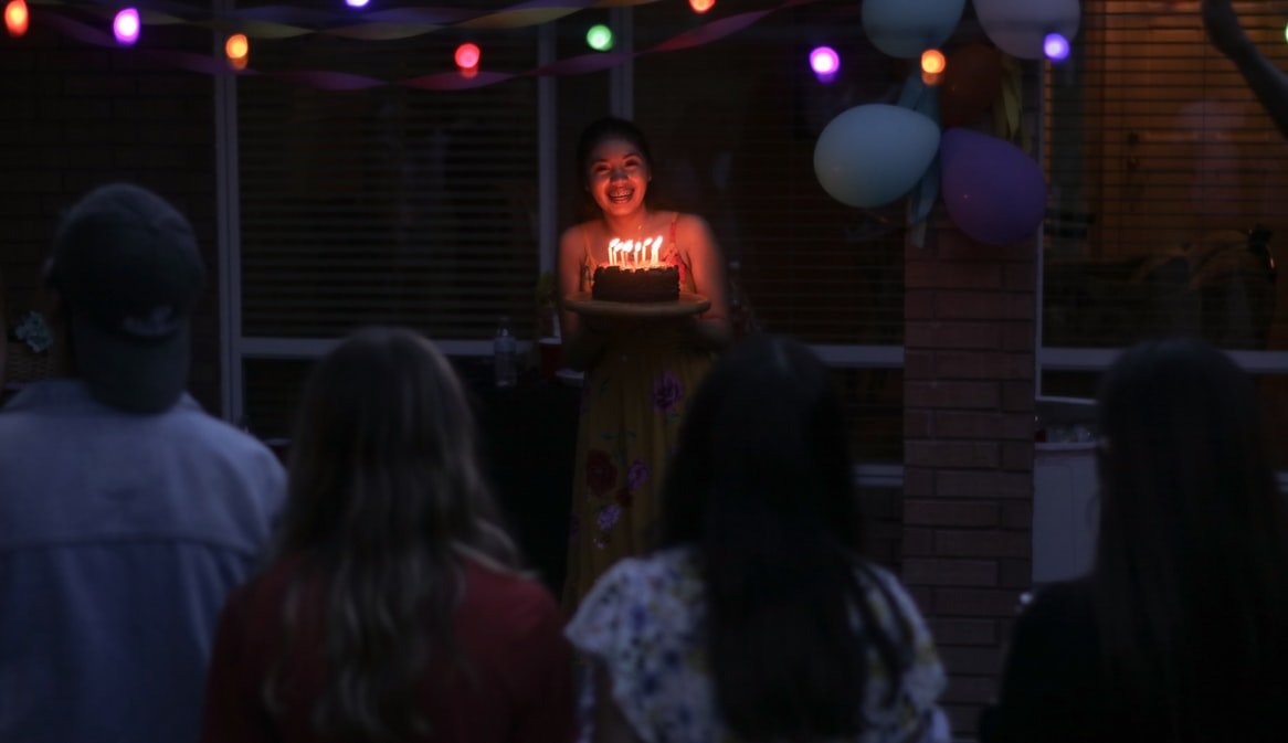 Mulher segurando bolo de aniversário
