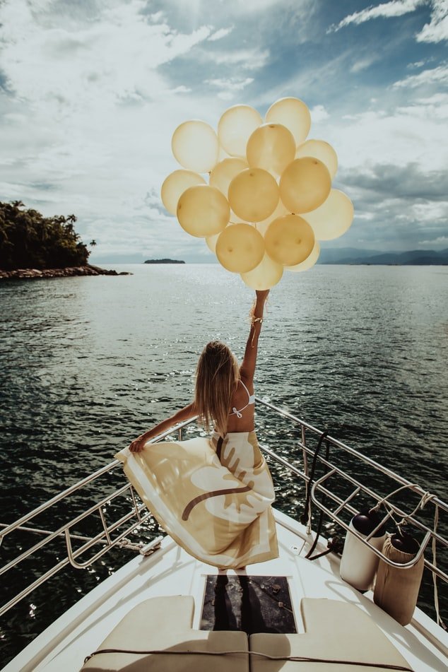 Mulher em barco segurando balões