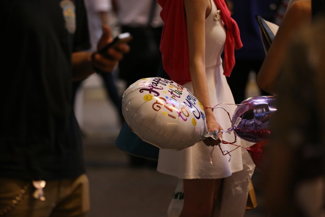 Mulher segurando balão de aniversário