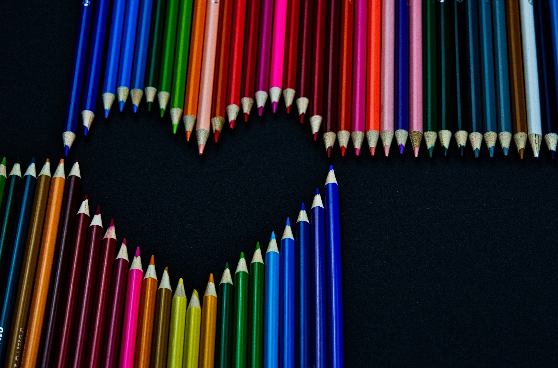 Lápis de cor variados alinhados para formar um coração