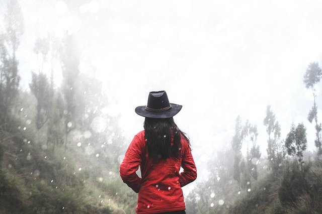 Mulher de casaco vermelho com chapéu de cowboy