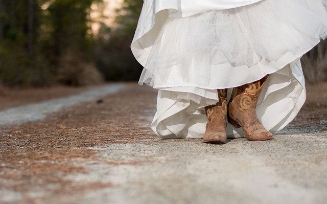 Mulher com vestido de noiva e botas de cowgirl