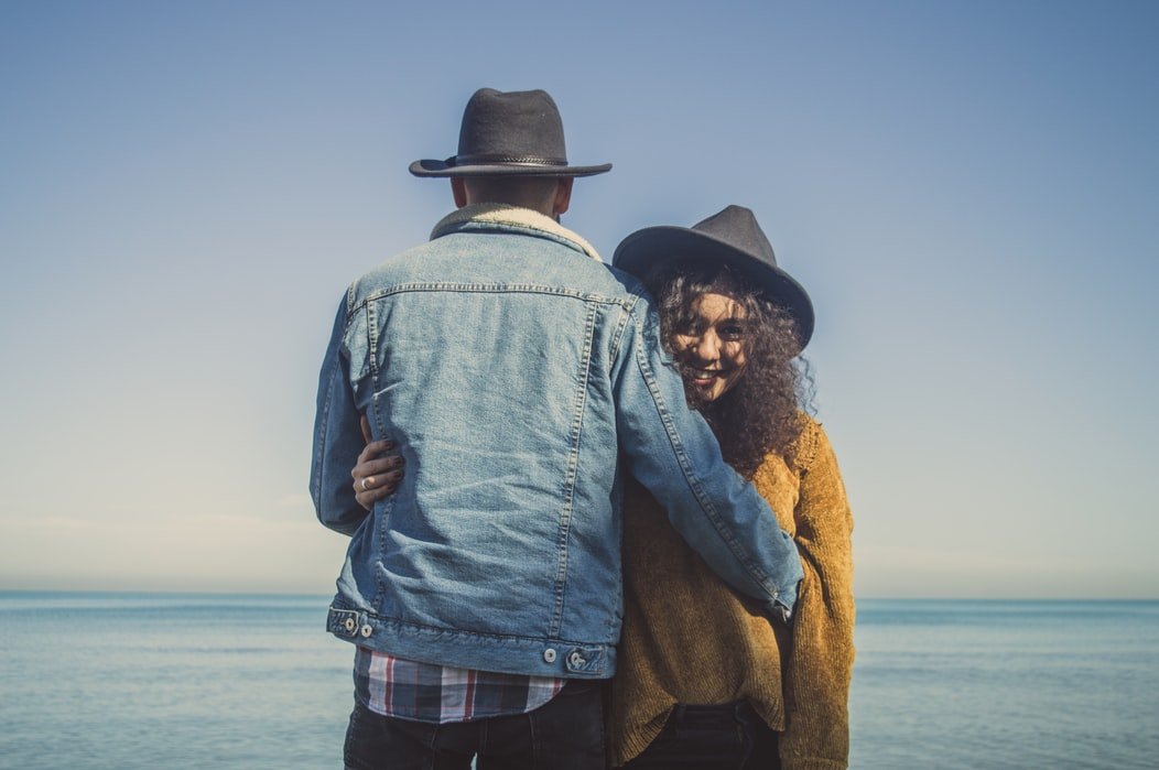 Casal com chapéus de cowboy de abraçado