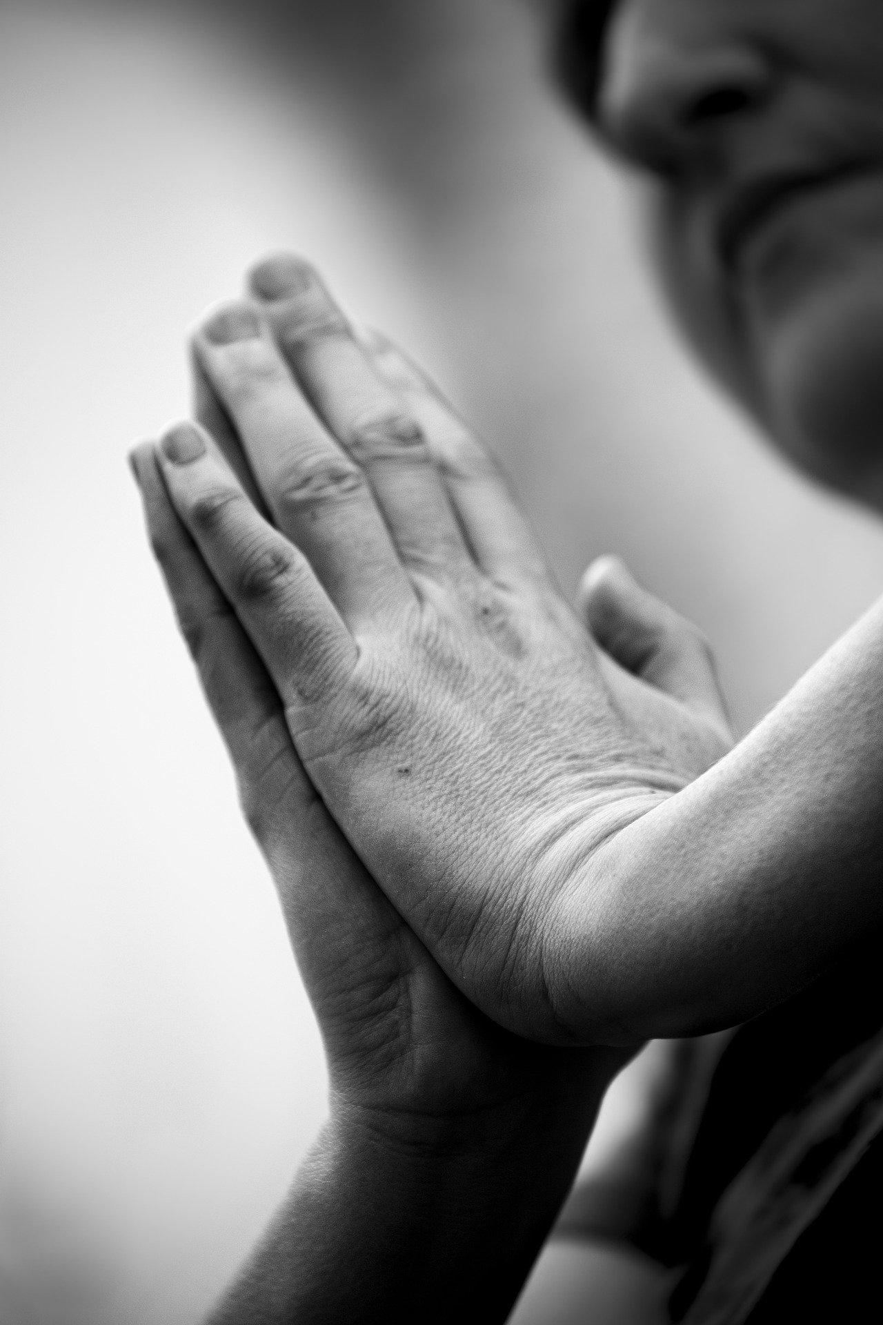 Pessoa orando com as mãos cruzadas