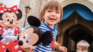 Criança na Disney segurando boneco do mickey