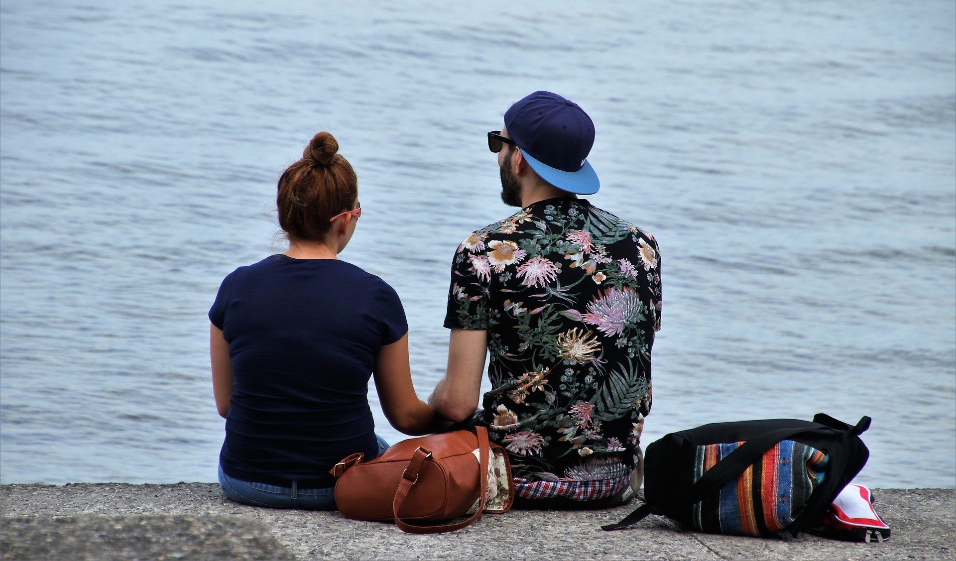 Homem e mulher sentados em frente do mar