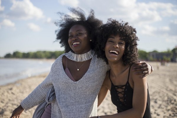 Pexels / Pixabay Duas mulheres negras, amigas se abraçando e sorrindo em praia
