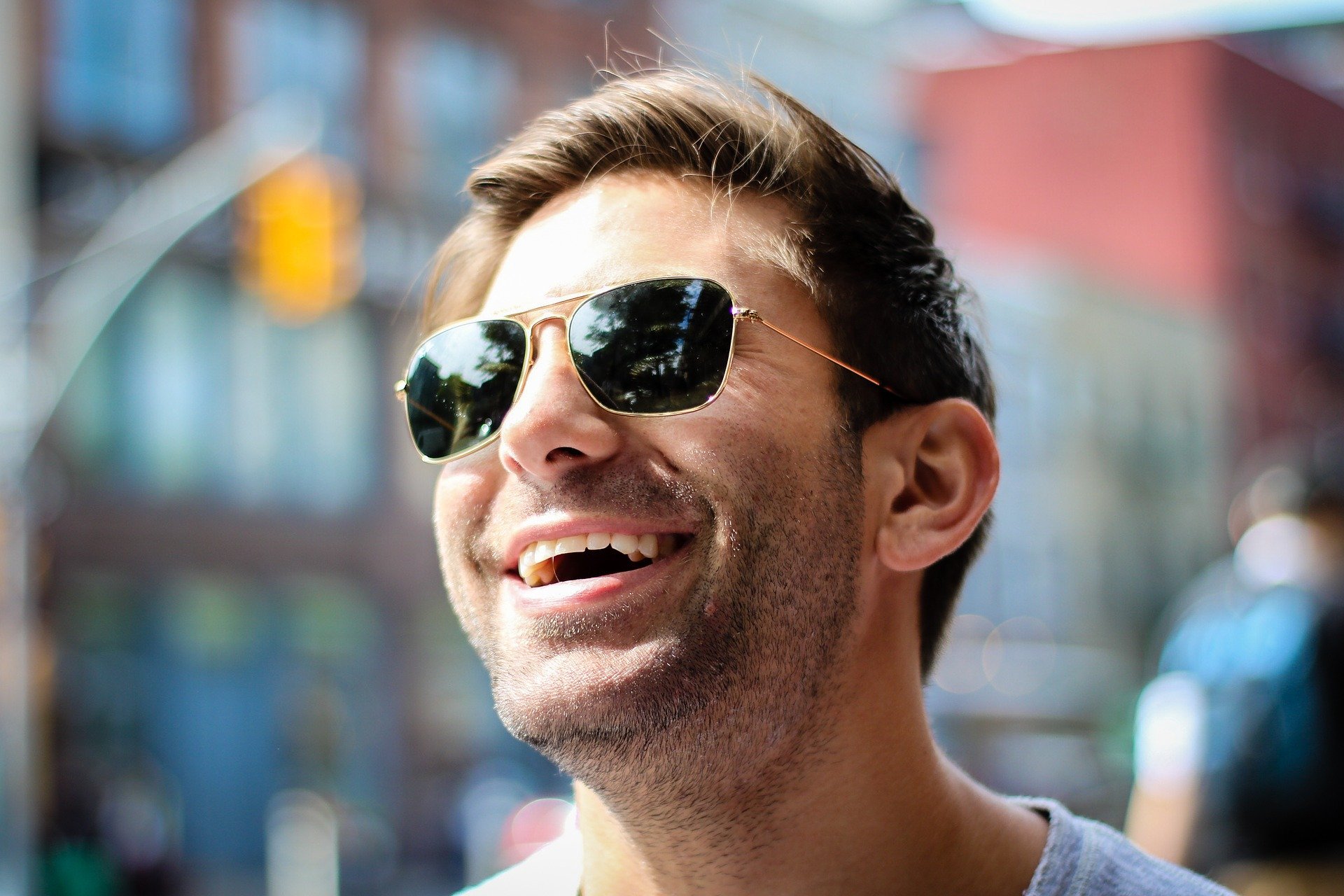Homem sorrindo usando óculos escuros