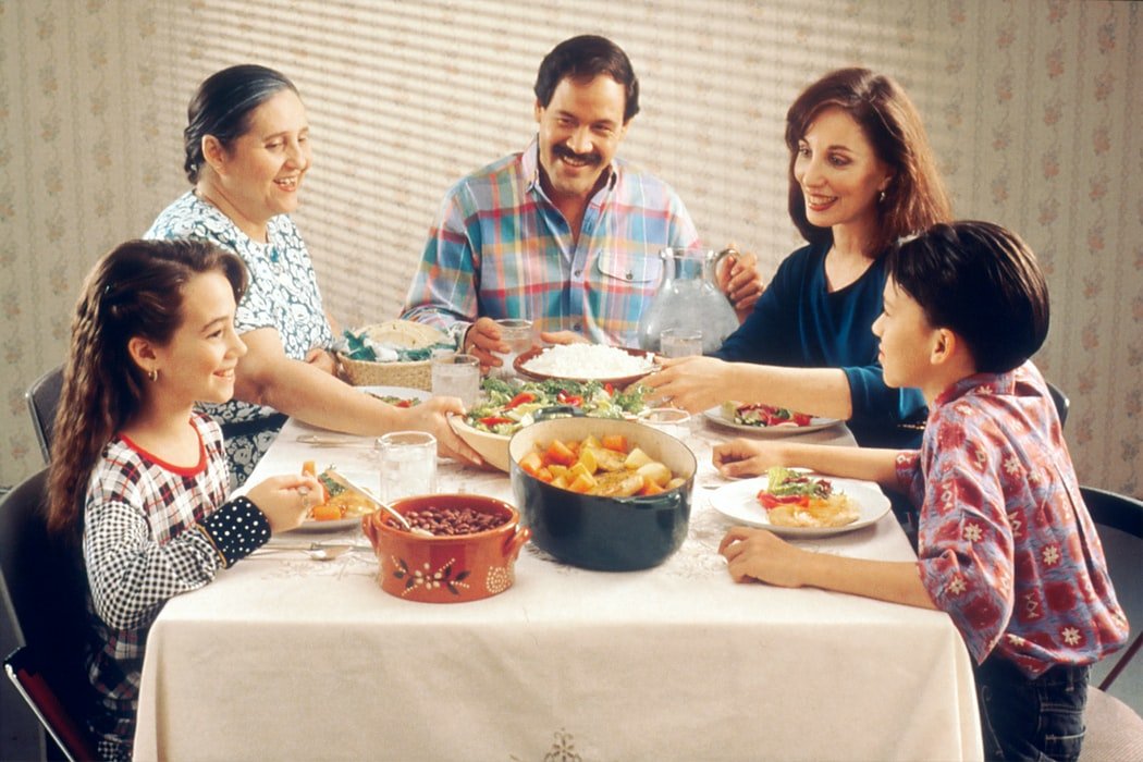 Família reunida jantando em mesa