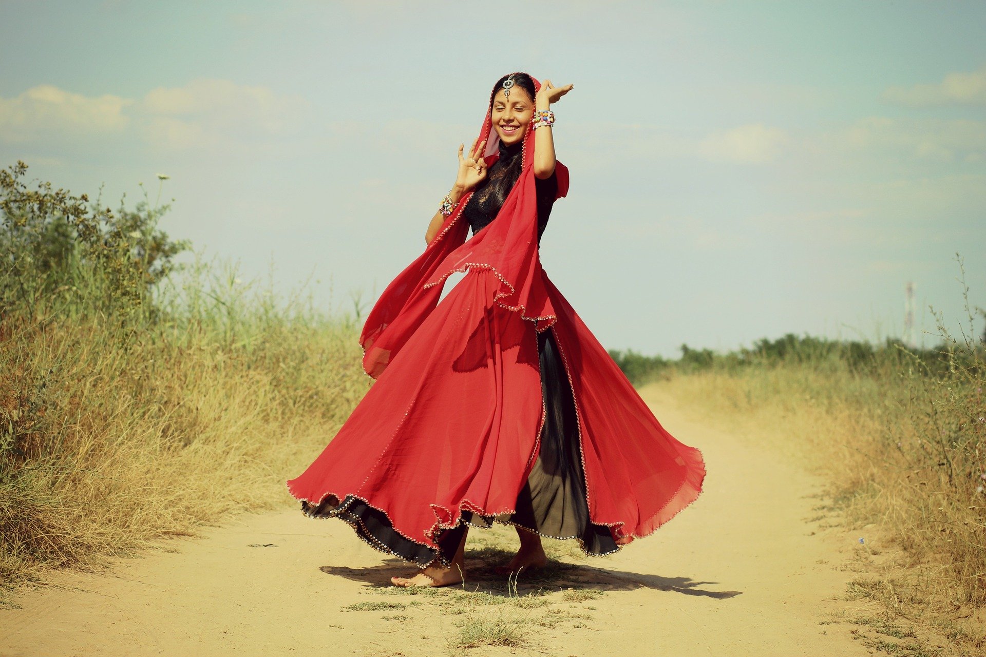 Mulher usando roupas indianas, dançando ao ar livre