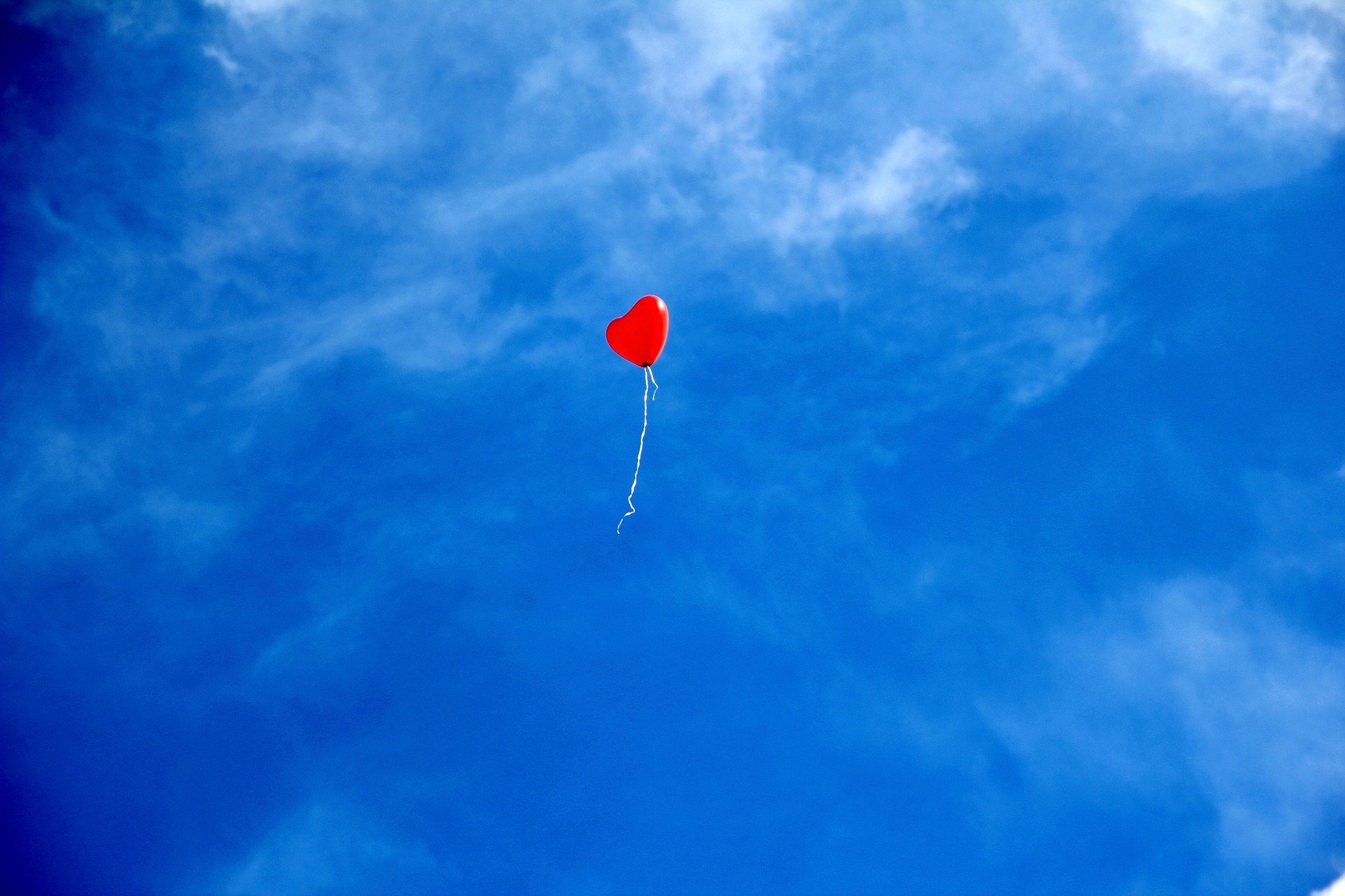Balão de coração voando solto em céu