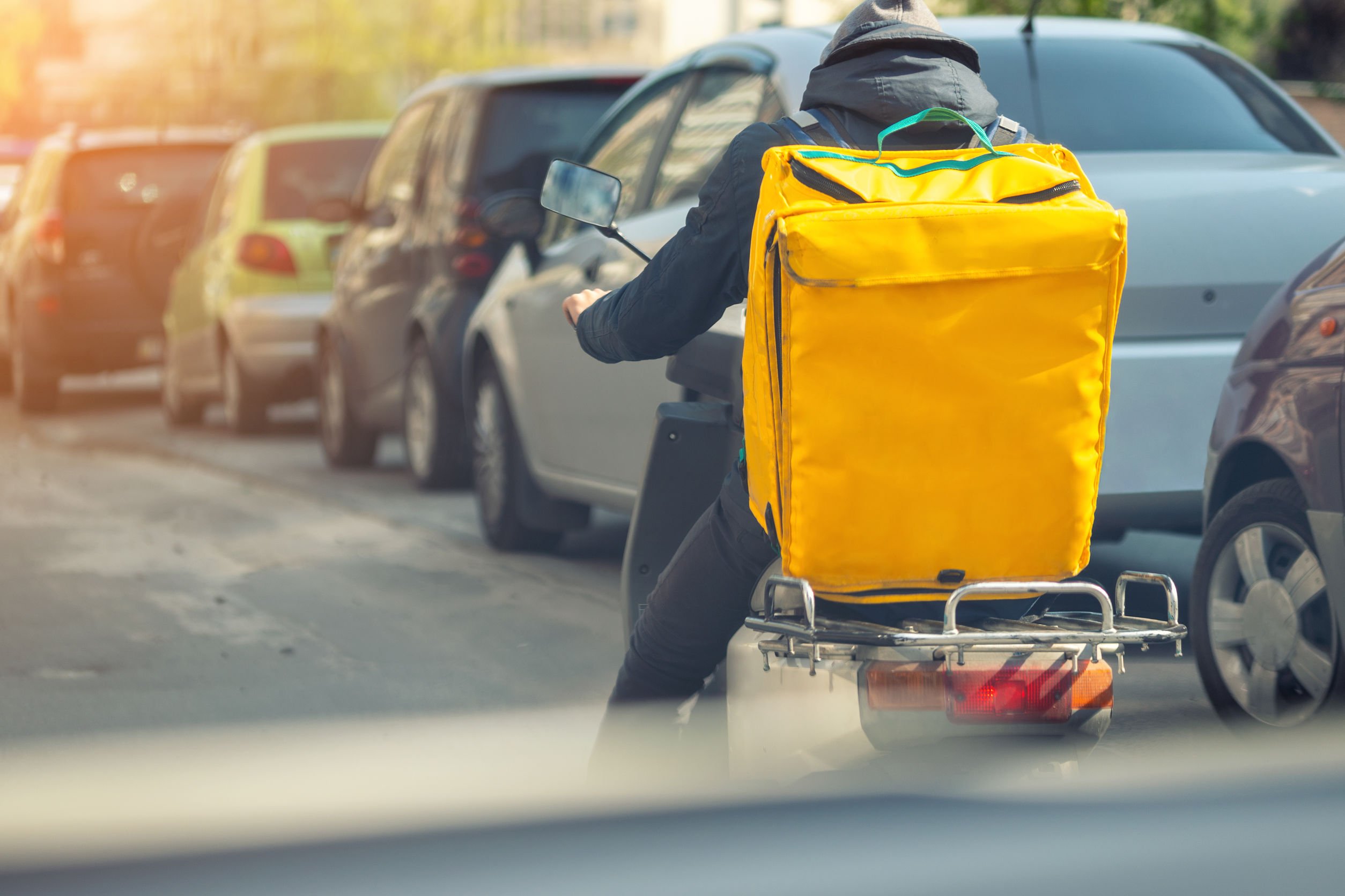 Homem em moto com mochila de entregador