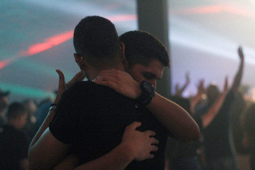 Homens amigos se abraçando em culto de igreja