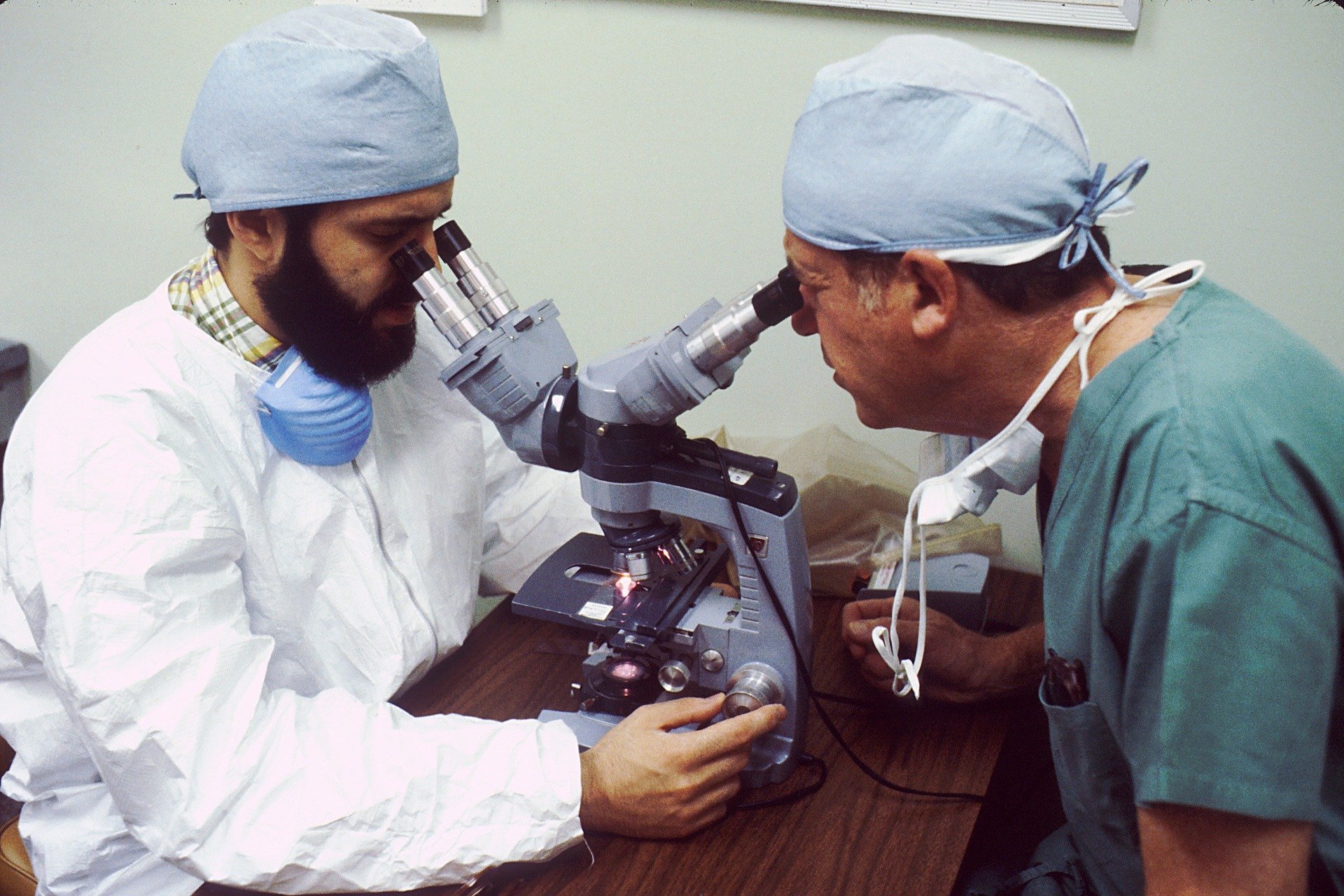 Dois cientista olhando em microscópio em laboratório