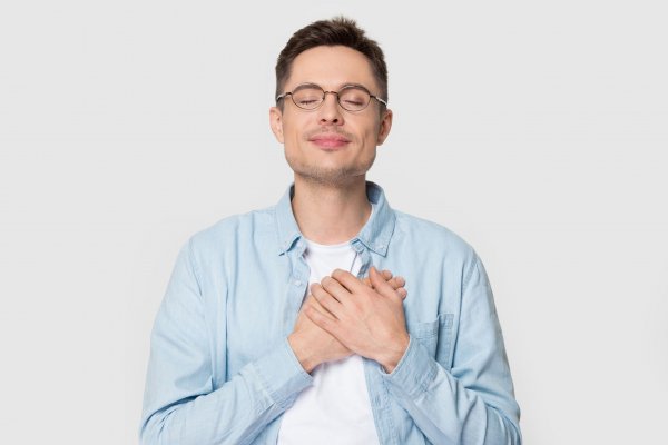 Aleksandr Davydov / 123RF Homem com olhos fechados e mãos sobre o peito, sorrindo