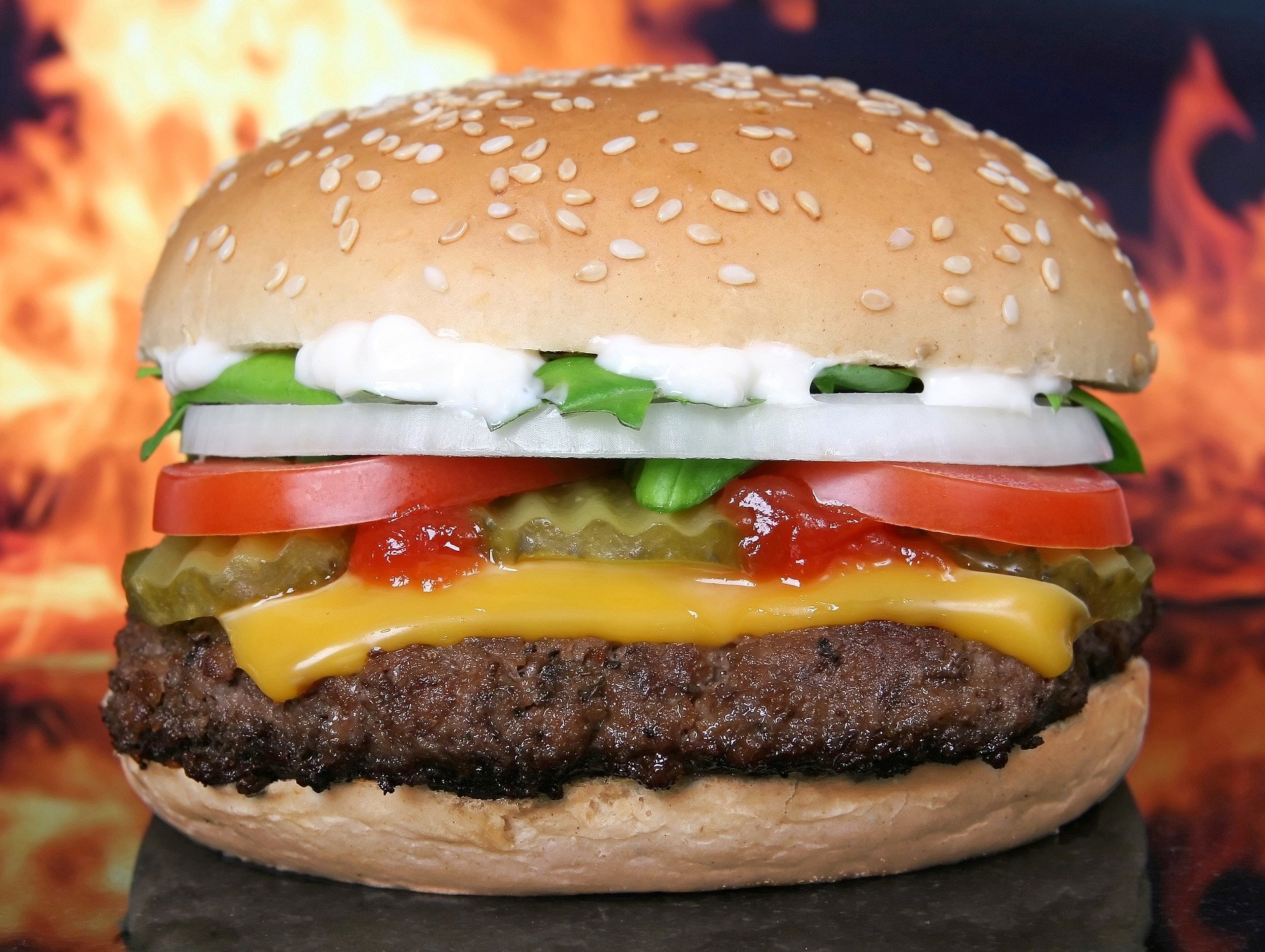 Hambúrguer de fast food em frente de labaredas de fogo