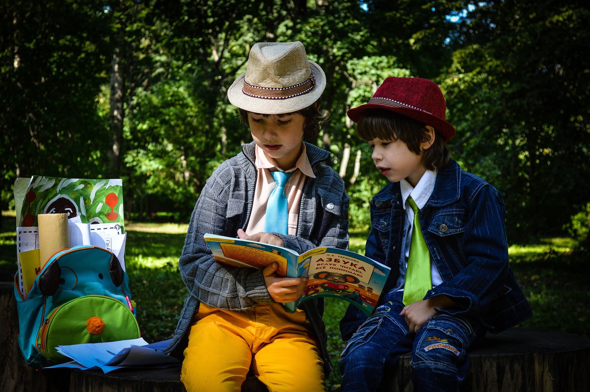 Crianças lendo um livro sentados em um parque