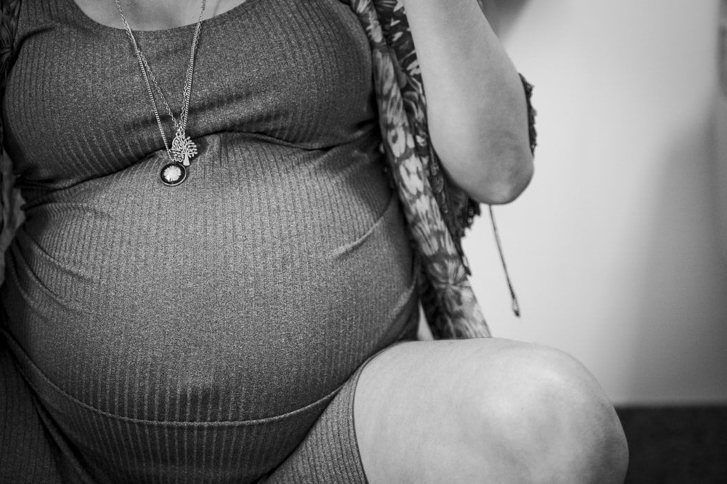 Foto preta e branca de close de barriga de grávida