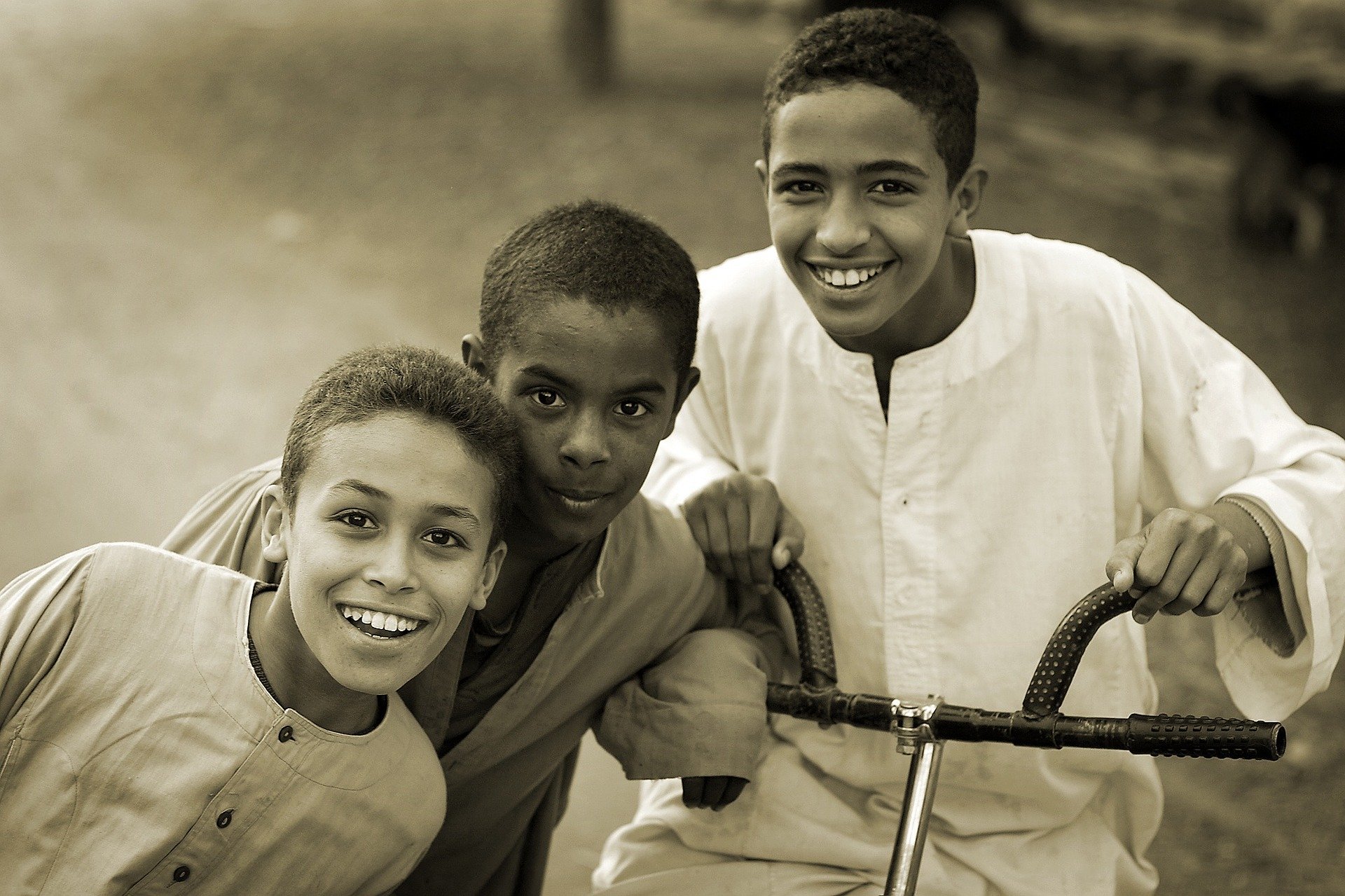 Meninos sorrindo ao ar livre em fotografia preta e branca