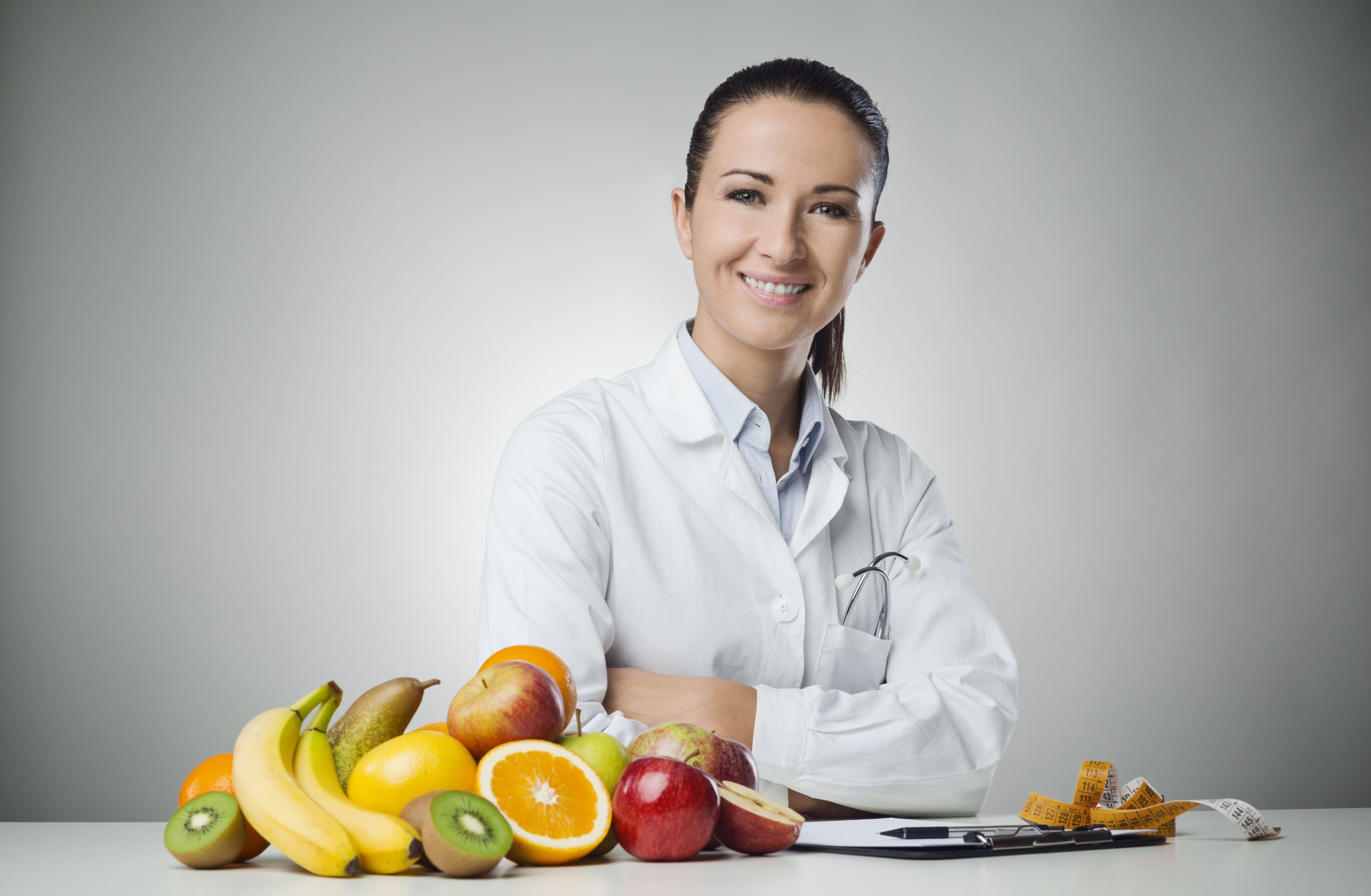 Mulher nutricionista e alimentos em cima de mesa