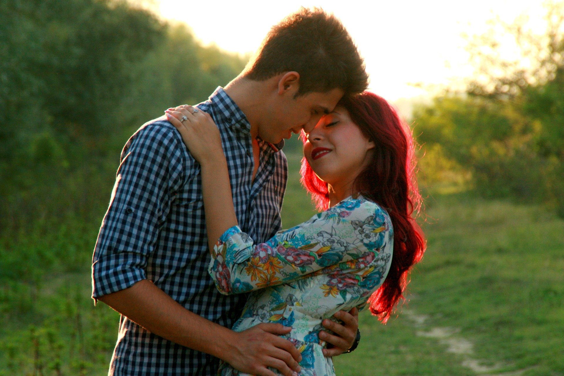Homem e mulher se abraçando e quase se beijando em meio de campo