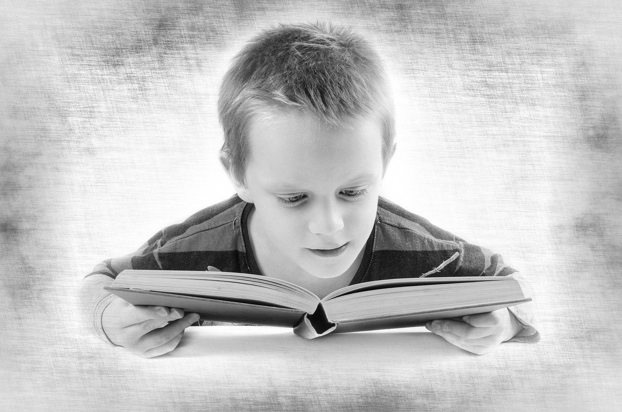 Ilustração gráfica preta e branco de menino lendo livro