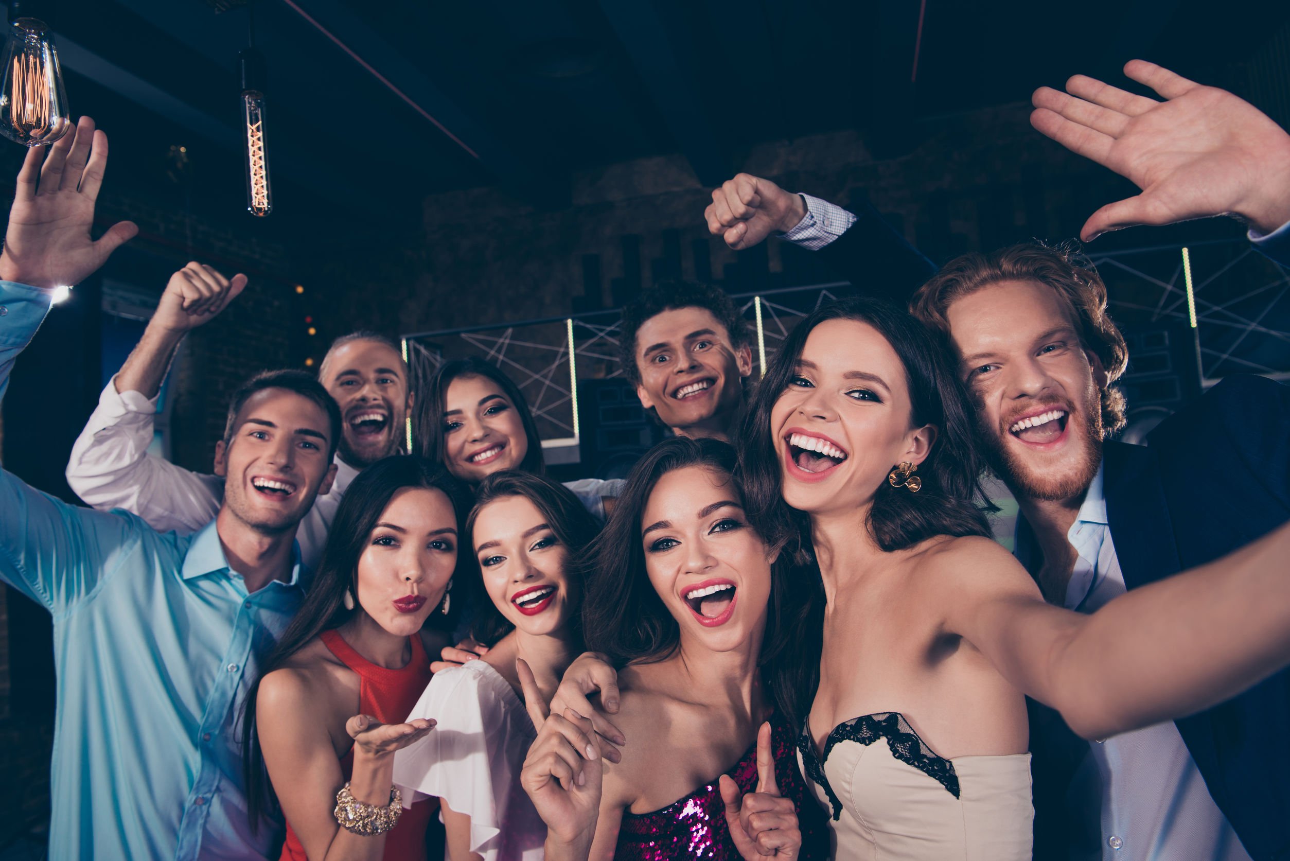 Pessoas sorrindo em selfie em fim de festa