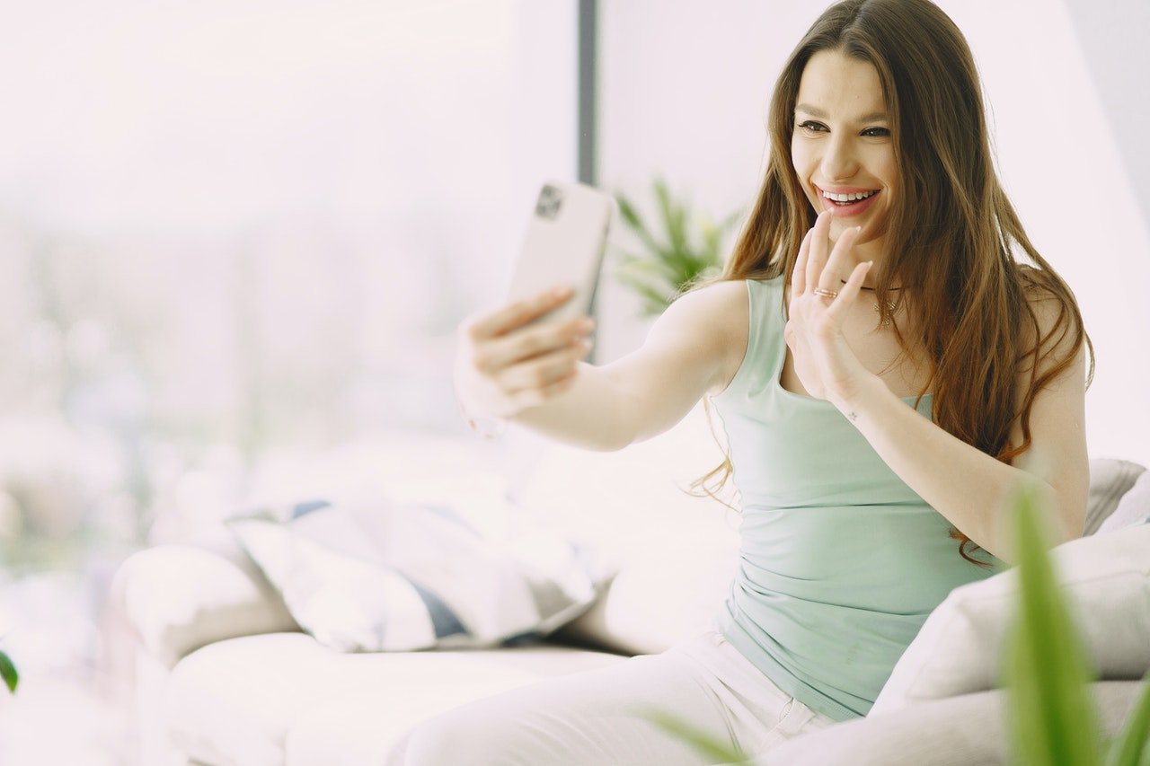Mulher gravando um vídeo de si mesma pelo celular