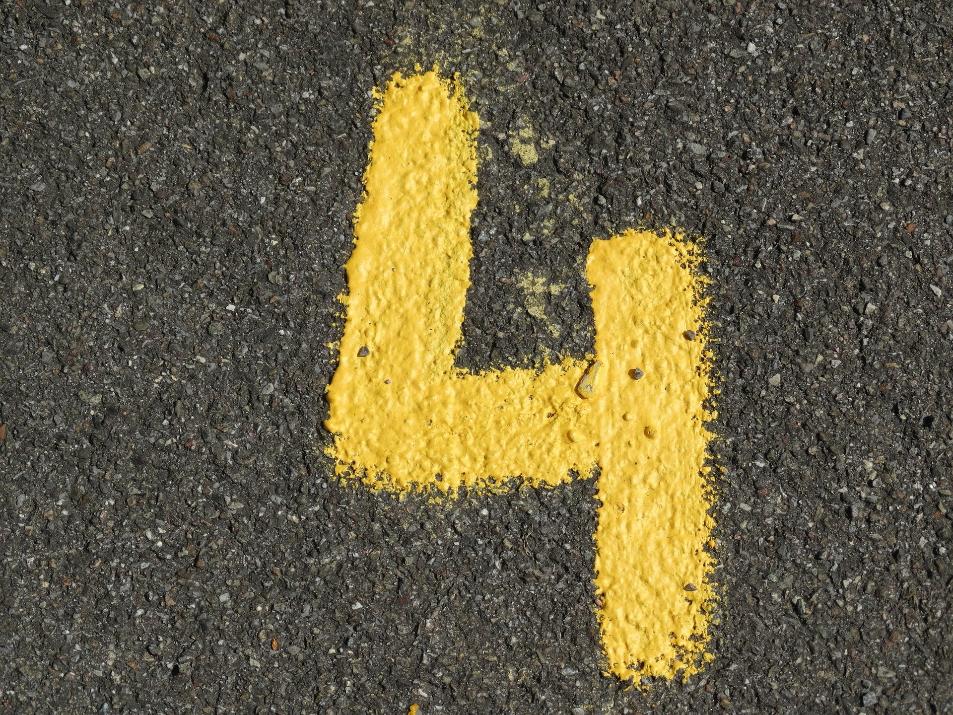 Número quatro escrito em asfalto com giz amarelo