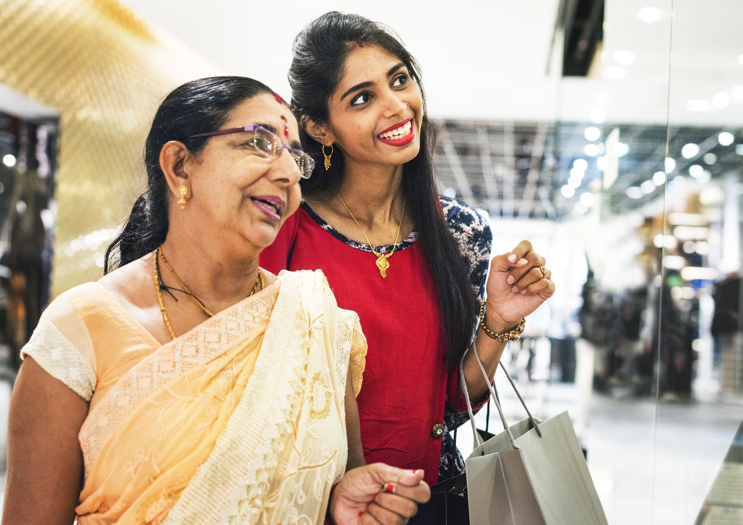 Mulheres indianas sorrindo em loja de shopping