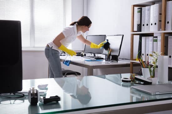 Mulher limpando tela de computador em um escritório