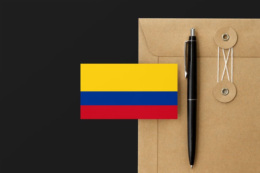 Bandeira da Colômbia em cima de papel pardo e caneta