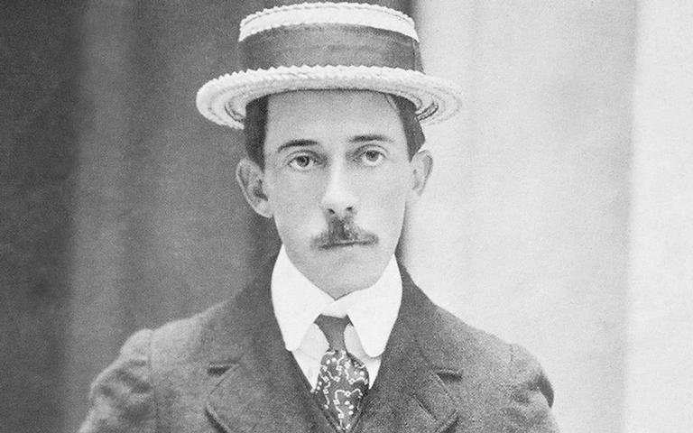 Santos Dumont com expressão séria, usando chapéu e terno.