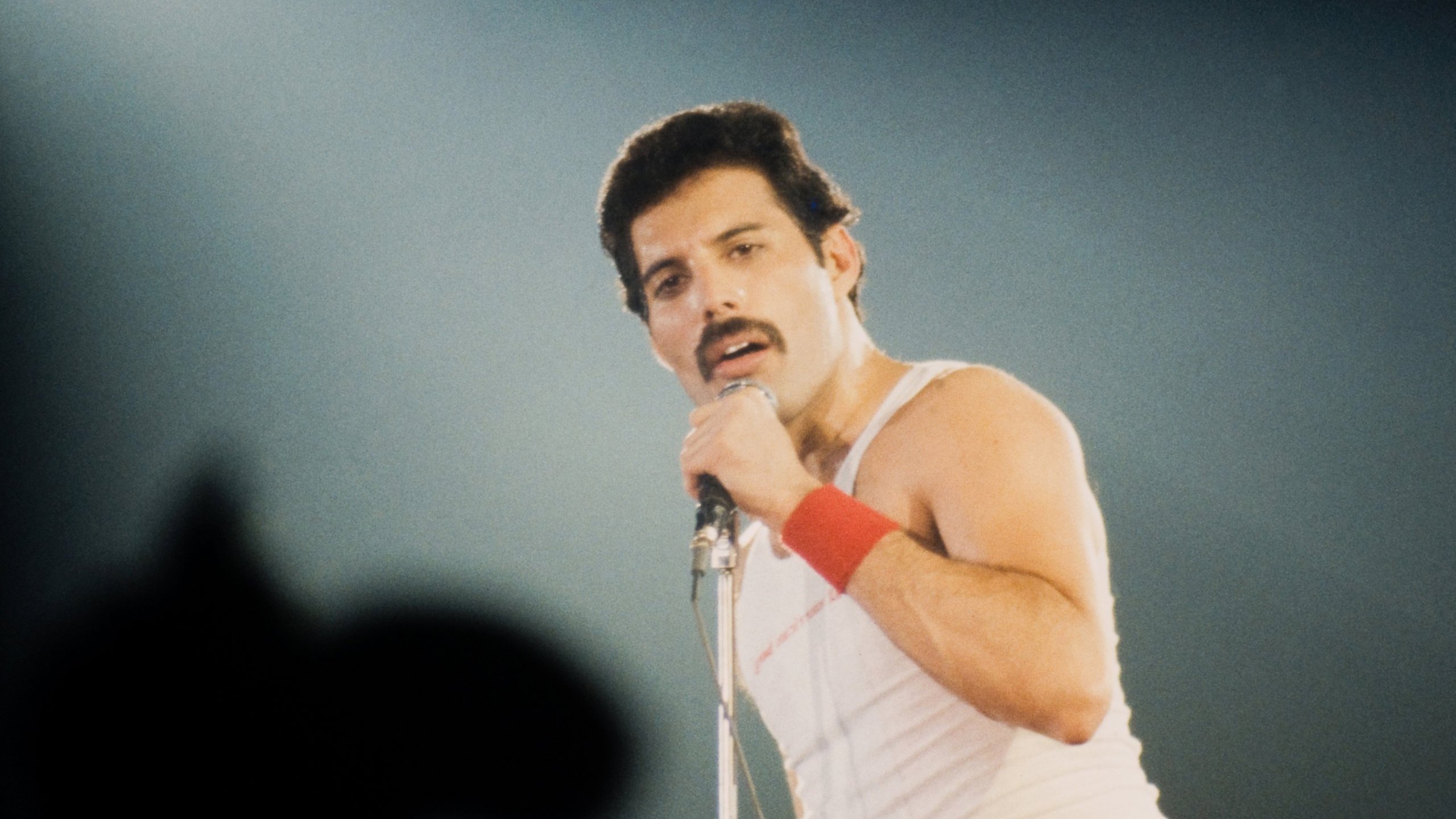 Freddie Mercury cantando em show com seu microfone