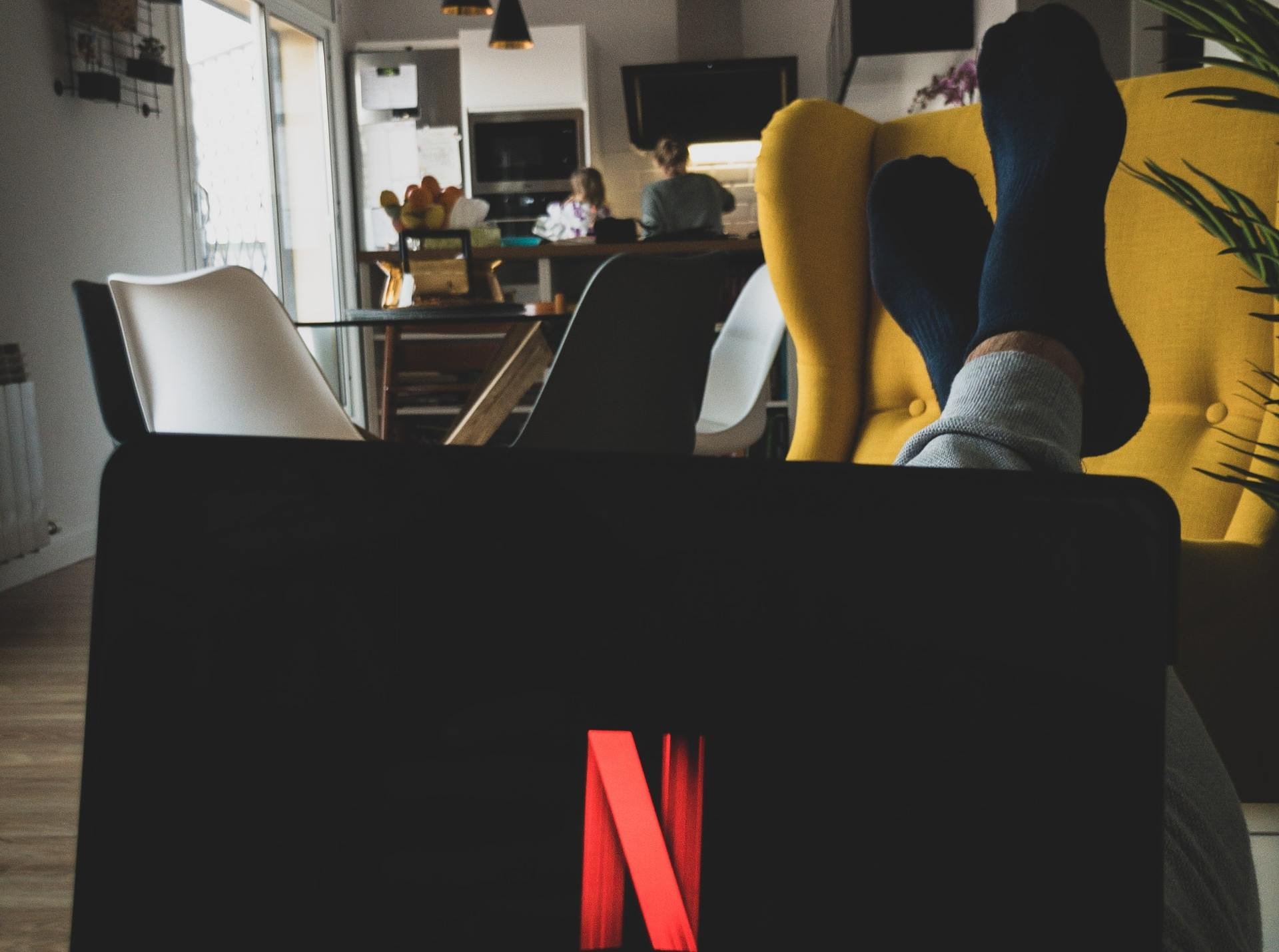 Notebook com logo da 'Netflix' com sala ao fundo.