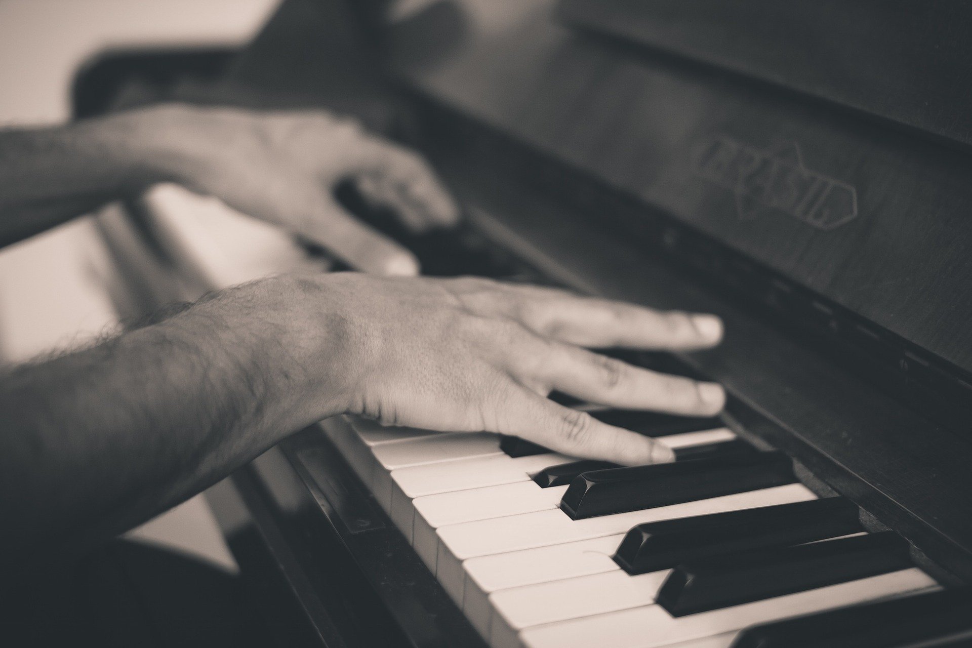 Mão de pessoa tocando piano.