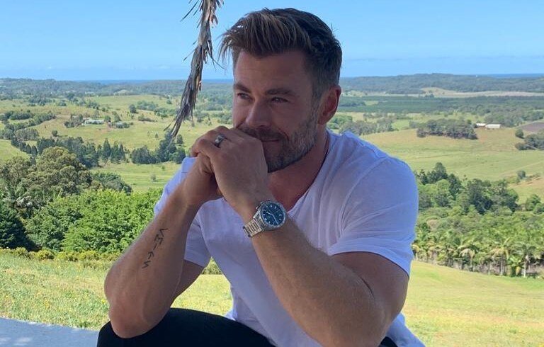 Chris Hemsworth numa paisagem de campo.