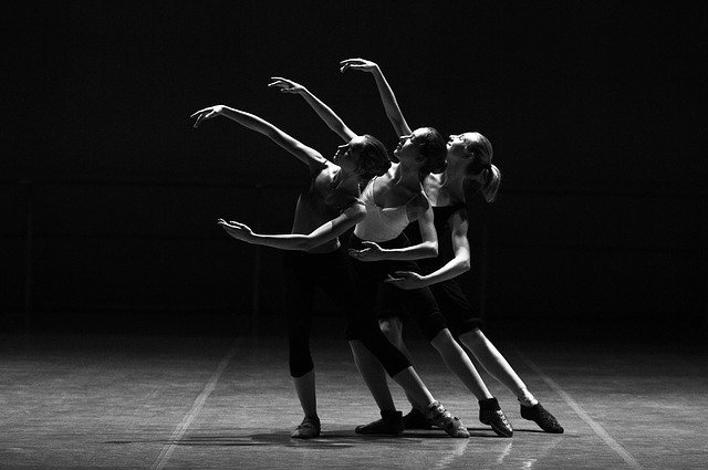 Três meninas dançando ballet em palco