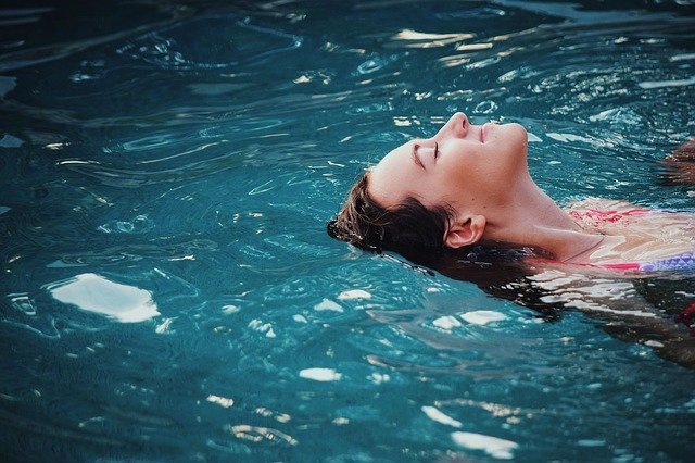 Mulher com olhos fechados em piscina
