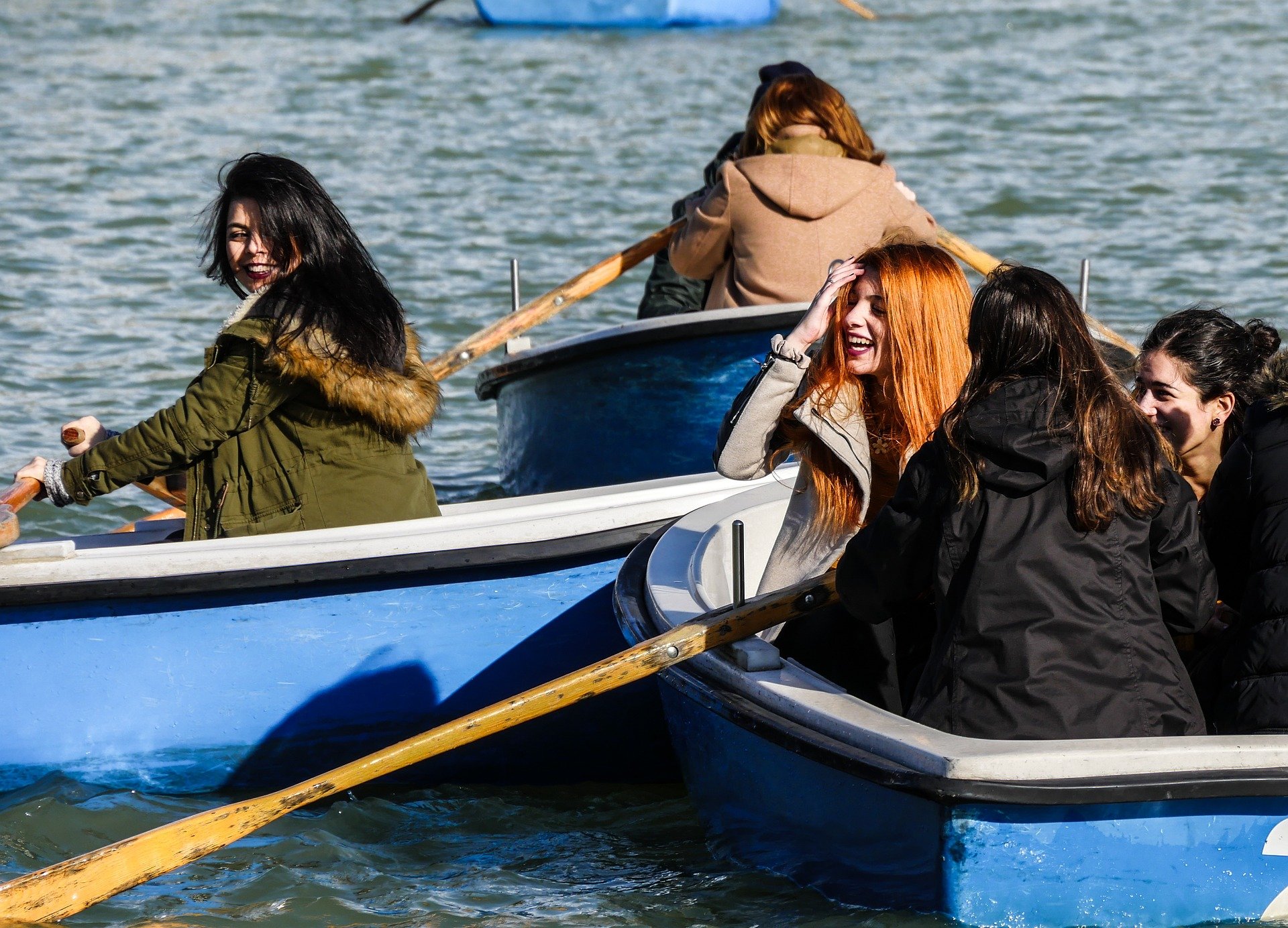 Grupo de amigas, sorrindo em barco.