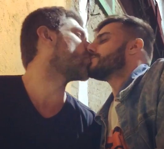 Hugo Bonemer e Conrado Helt trocam um beijo.