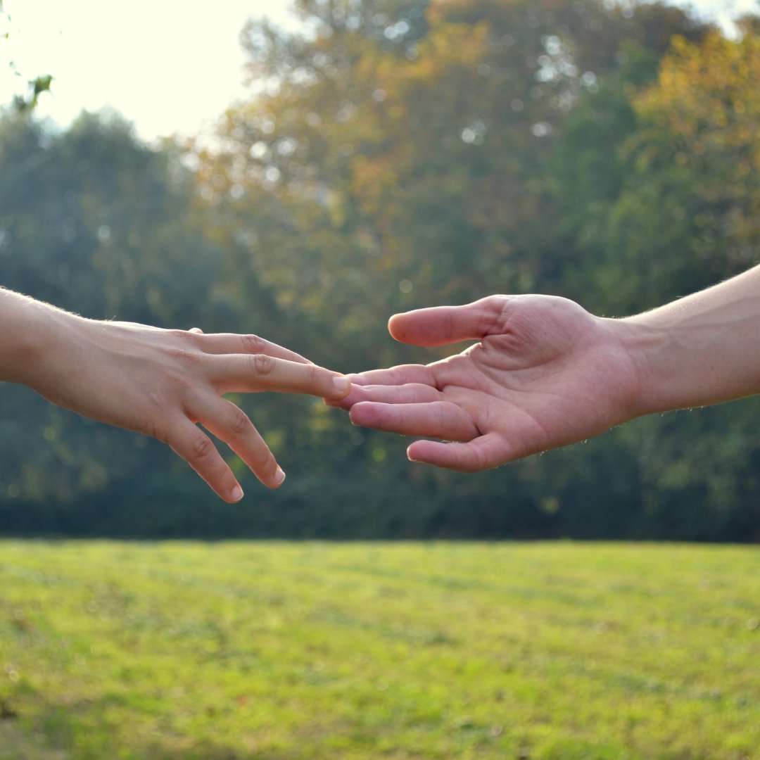 Foto de duas pessoas encostando as mãos