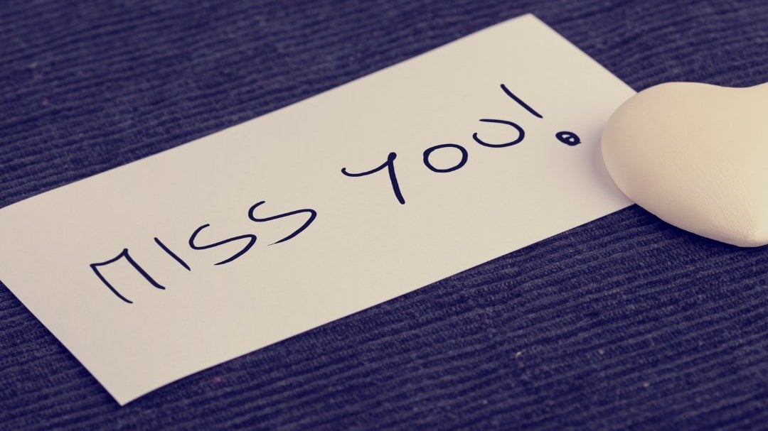 Imagem da palavra 'miss you' escrita em um papel