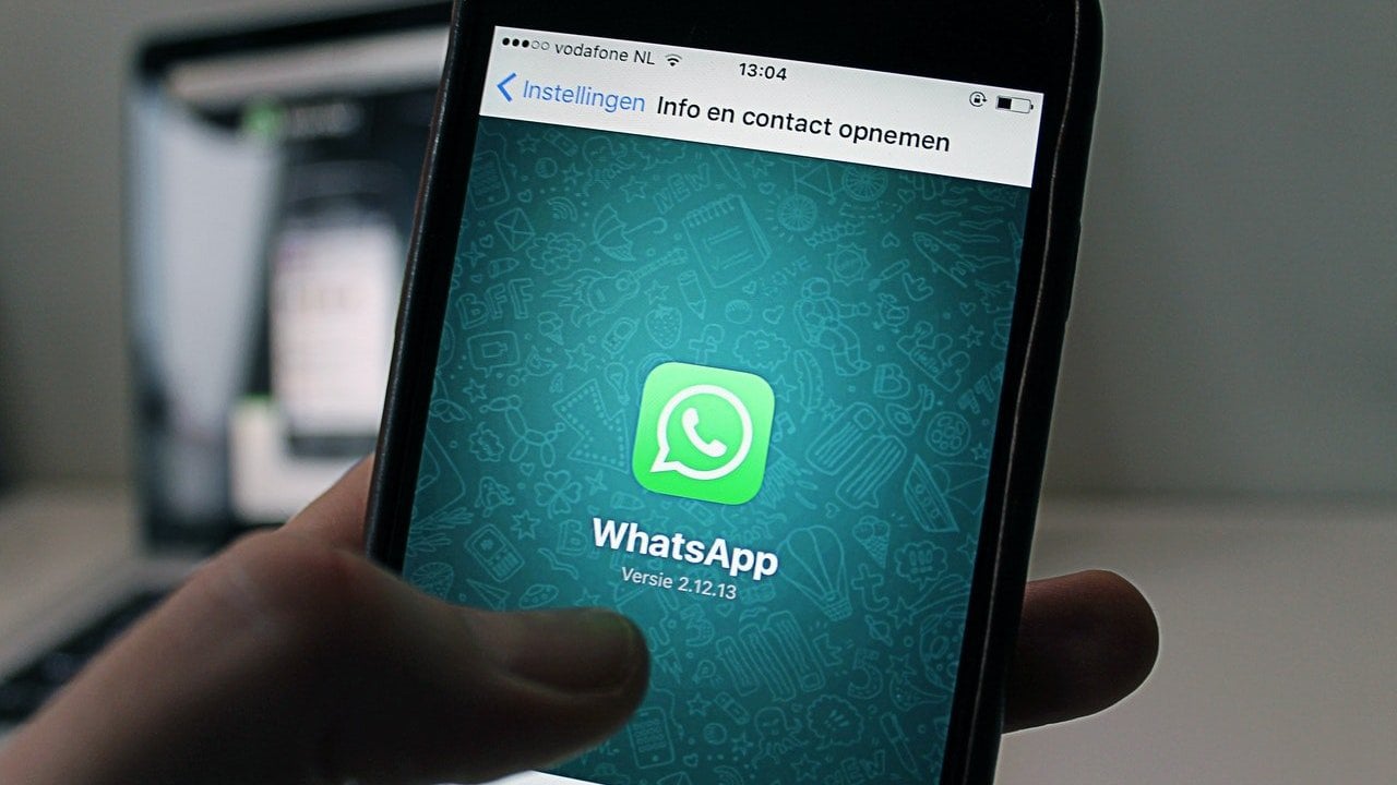 Recorte de uma pessoa segurando o celular olhando o Whatsapp.