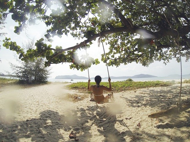 Mulher em balanço na praia