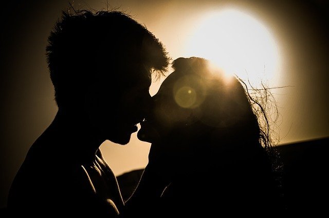 Sombra de casal beijando-se e Sol ao fundo