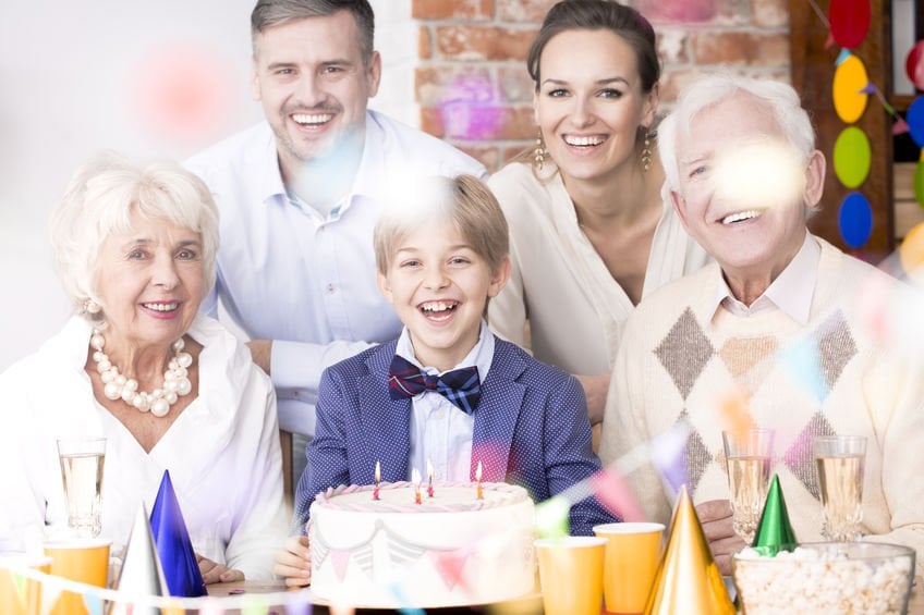 Família reunida e sorrindo em aniversário de menino