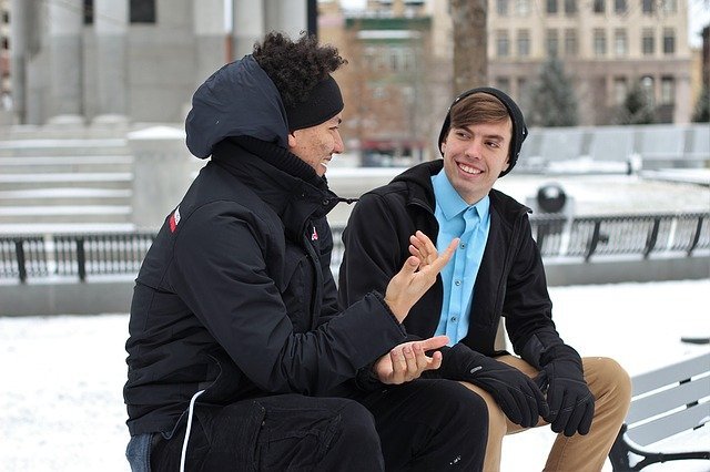 Amigos conversando em parque com neve