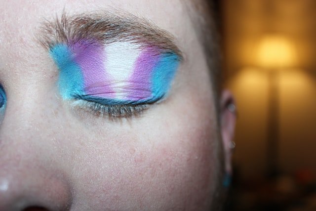 Pessoa com maquiagem com as cores da bandeira trans